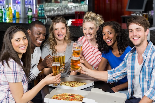 Happy friends having a drink and pizza