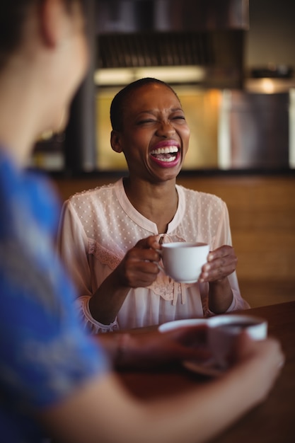 Happy friends interacting while having coffee