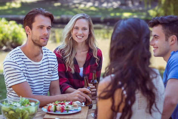 Happy friends in the park having lunch