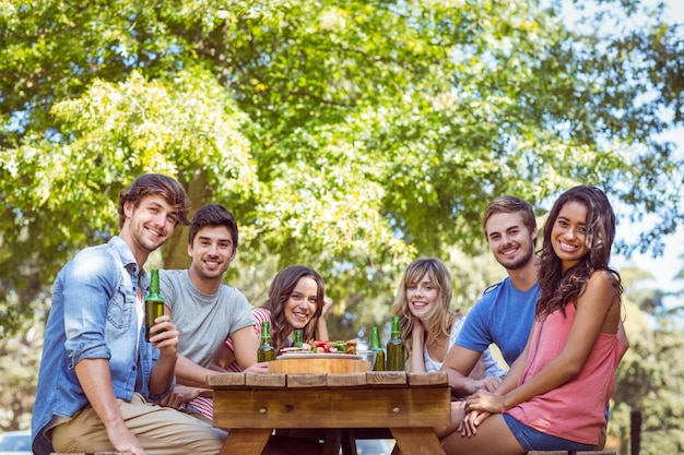 Happy friends in the park having lunch