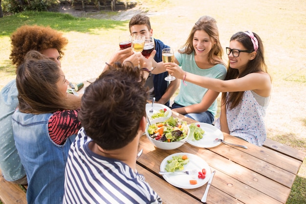 Happy friends in the park having lunch