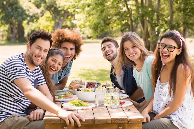 Happy friends in the park having lunch