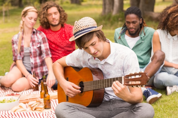 Happy friends in the park having picnic