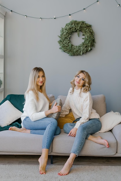 Happy friends or sisters are ready to celebrate Christmas and New Year at home