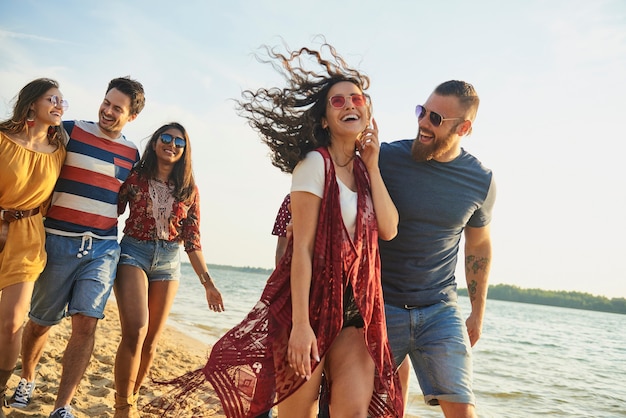 Happy friends walking on the beach.