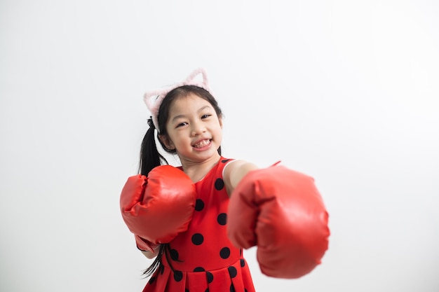 Happy funny little girl with red boxing gloves isolated