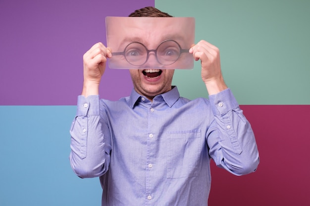 Happy funny man looking through a magnifying glass