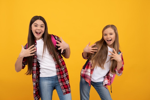 Happy funny teen girls in casual checkered shirt carry backpack school fun