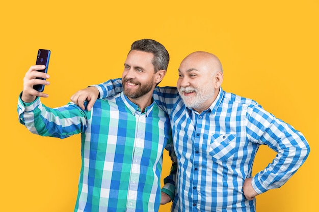 Happy generation men make selfie isolated on yellow generation men make selfie in studio