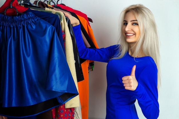 Happy girl chooses clothes in shop