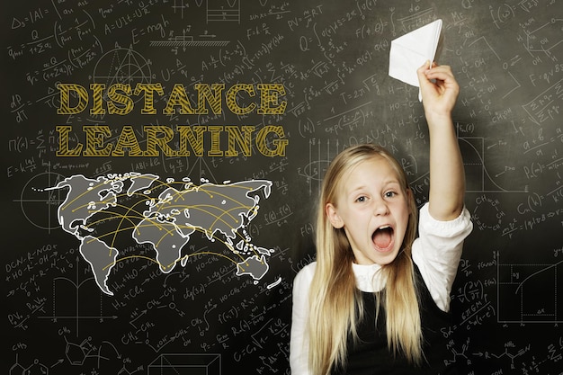 Happy girl and distance learning concept on blackboard background