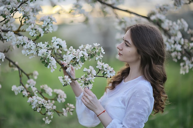 happy girl dreaming in a blooming garden, fresh tenderness spring woman in flowers