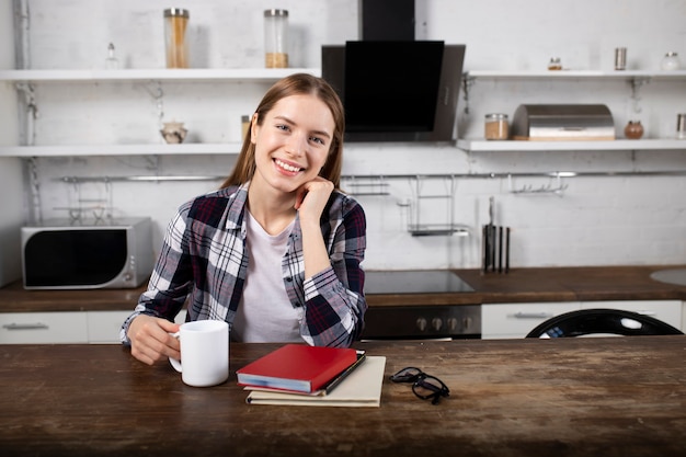 Happy girl drinks coffee and reads a book in the morning