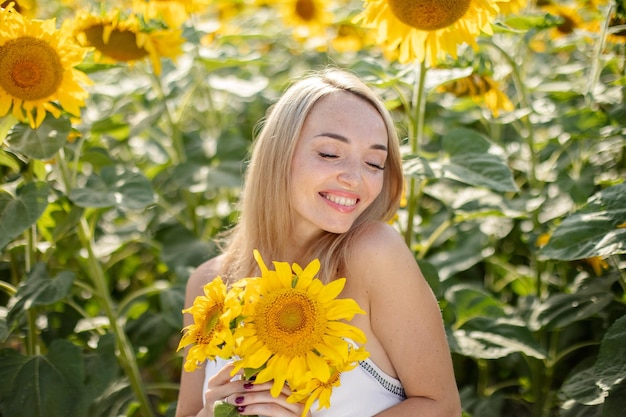 Happy girl enjoys spending time in a field with sunflowers