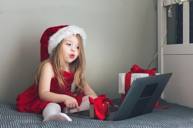 A happy girl in a festive red Santa hat