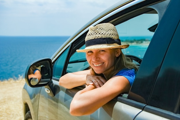 A happy girl from car at sea