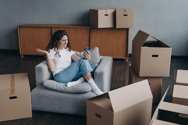 Happy girl having video call on phone showing her dream house Mortgage loan concept