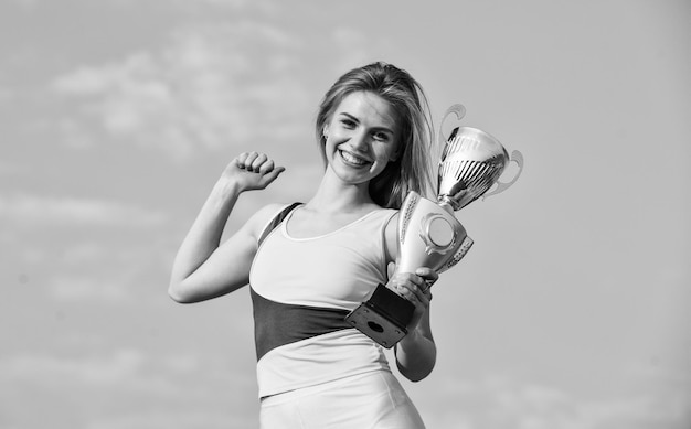 Happy girl hold trophy Sport success Gold prize Cute athlete being awarded with cup First place award and success girl hold a golden trophy woman won the competition woman winner success award