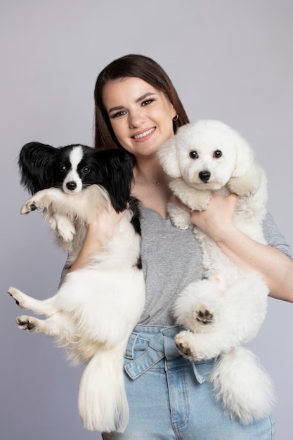 Happy girl holding cute bichon and papillon dogs