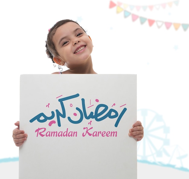 Happy Girl Holding Ramadan Greeting Board, Arabic Text Translation "Holy Blessed Month of Ramadan"