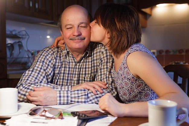 A happy girl kisses her dad on the cheek Payment of debts or education of their children