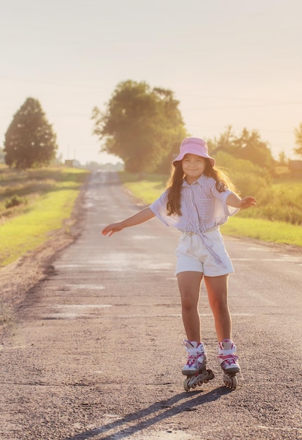 Happy girl on roller skates in summer road