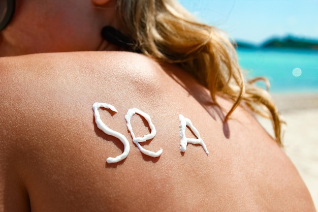 Happy girl on the sea with a picture of the sun on her back