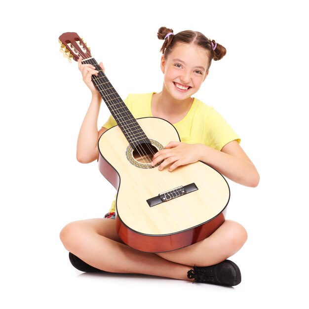 a happy girl sitting over white background with a guitar