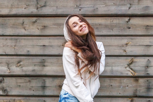 Happy girl smiling. Beauty portrait young happy positive laughing brunette woman on wooden wall 