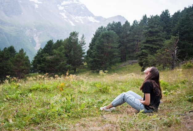 Happy girl in the summer in the mountains in the rain