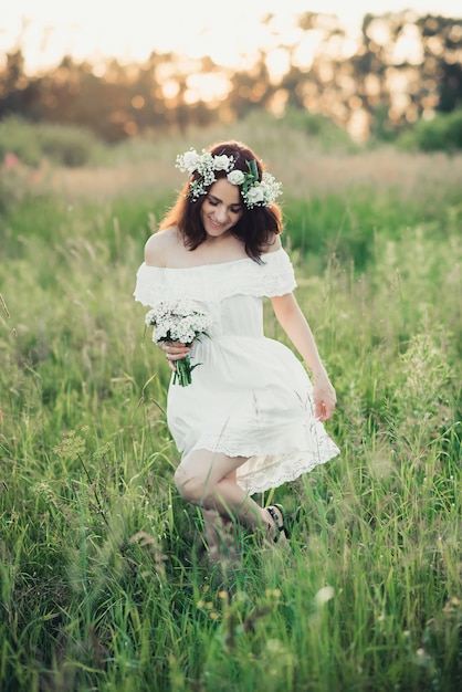 Happy girl in a white dress and a bouquet of flowers smiles and joy