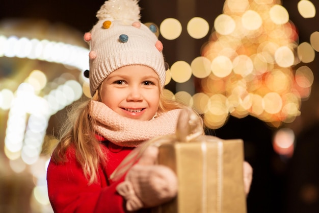 Photo happy girl with gift box at christmas market