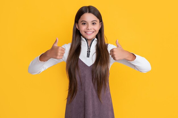 Happy girl with long hair on yellow background thumb up