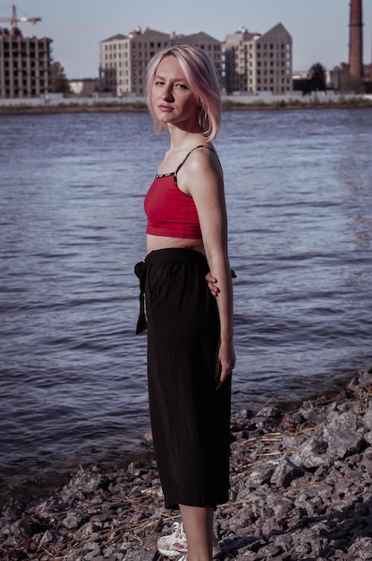 Happy girl with short hair and a red top on the seashore