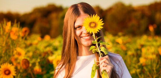 Happy girl with sunflower in her hand