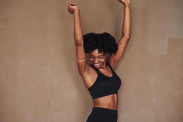 Happy girl. Young beautiful afro american woman  against brown space