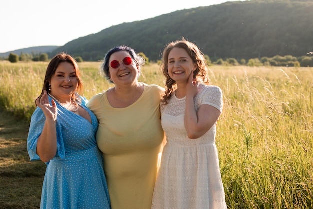 The happy girlfriends are hugging in nature