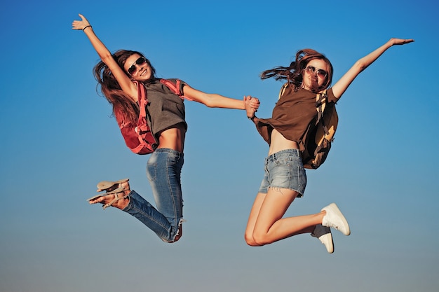 Happy girls jumping on sky