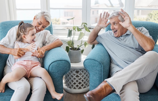 Happy grandfather and grandmother with child excited and bonding being silly goofy or funny in living room at home Elderly man senior woman or grandchild being playful connect or laugh together