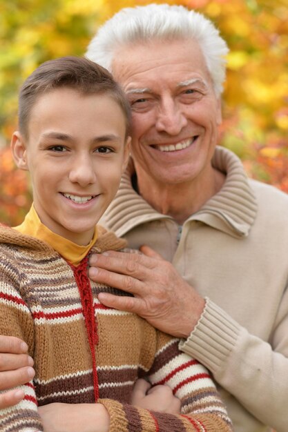 Happy grandfather and grandson hugging  in park