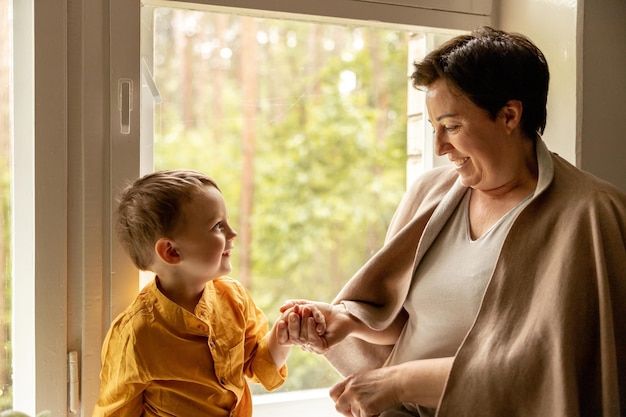 Happy grandmother and grandson enjoy time together Positive middle age woman spending time with little cute grandchild 50yearold grandma with grandkid Multigenerational family