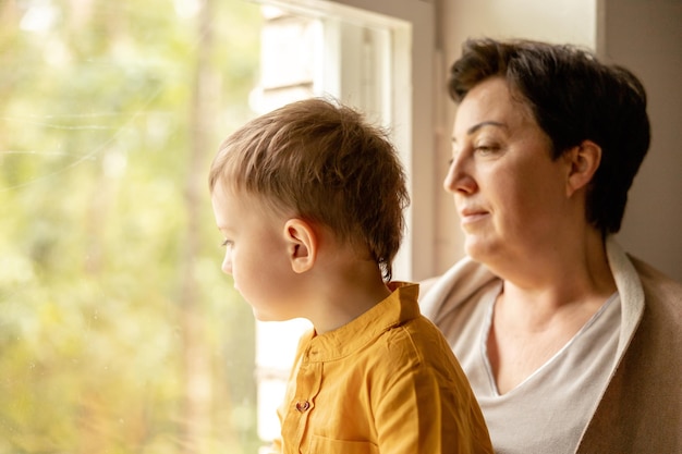 Happy grandmother and grandson enjoy time together Positive middle age woman spending time with little cute grandchild 50yearold grandma with grandkid Multigenerational family