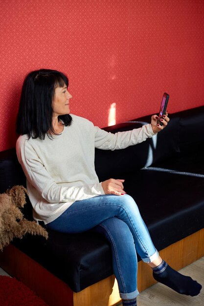 Happy grandmother having videocall on cellphone online talk with granddaughter