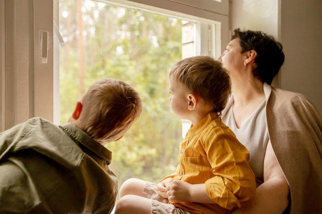 Happy grandmother and her grandsons enjoy time together Positive middle age woman spending time with little cute grandchildren 50yearold grandma with grandkids Multigenerational family