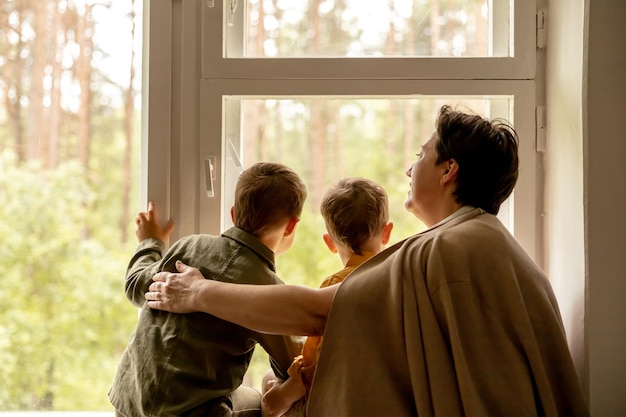 Happy grandmother and her grandsons enjoy time together Positive middle age woman spending time with little cute grandchildren 50yearold grandma with grandkids Multigenerational family