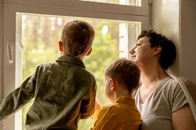 Happy grandmother and her grandsons enjoy time together Positive middle age woman spending time with little cute grandchildren 50yearold grandma with grandkids Multigenerational family