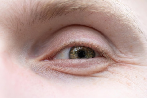 Happy green eye of a man closeup The eye of a European blond male with freckles