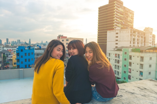 Happy group of asia girl friends enjoy and play sparkler at roof top party at evening sunset