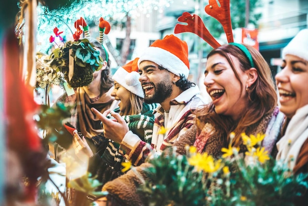 Happy group of friends having fun at Christmas Market souvenir shop