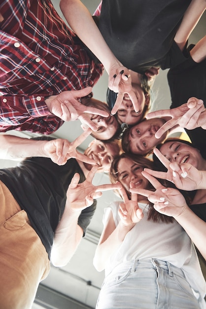 Happy group of friends with their hands together in the middle.